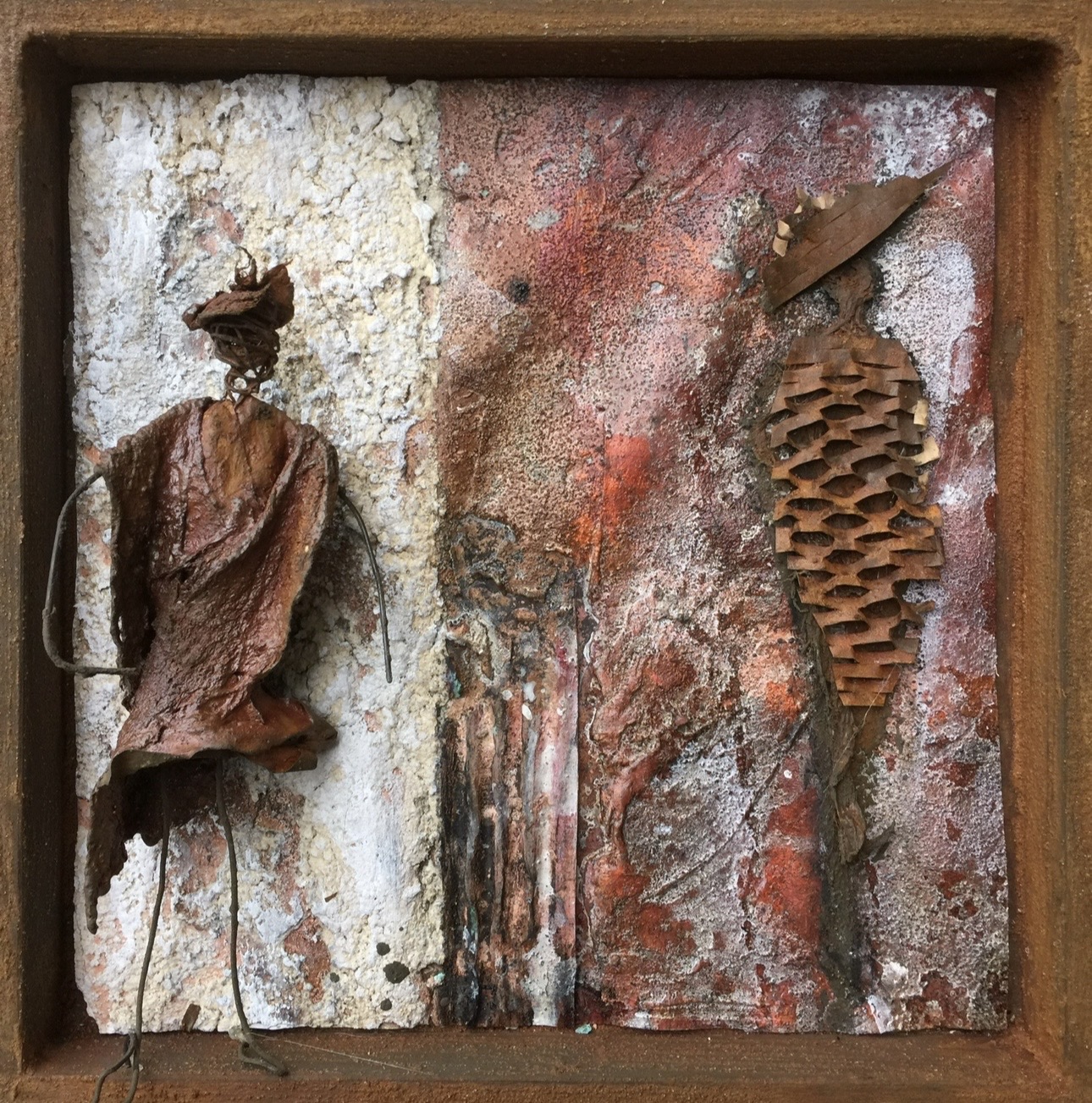 Rostfigur und Materialobjekt im Rahmen